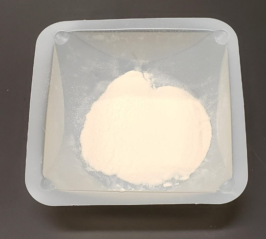 sodium alginate (a white powder) in a weigh boat